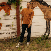 Men's Sixty Six Sneaker in Surplus Green canvas, worn with dark jeans, full-length view in front of a horse mural
