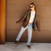 Women's Ballard Boot in Coffee Bean leather, worn by a person standing against a brown wall in a green jacket