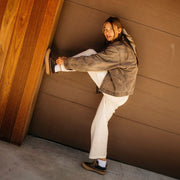Women's Carson 3 Eye Boot in Peacoat Navy/Bark leather, worn by a person leaning on a brown wall with one leg raised
