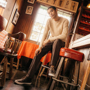 Men's Maslon Desert Boot in Charcoal leather, worn with brown pants by a person seated on a bar stool