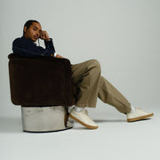 Men's Diamond Cup sneaker in Black leather, ecru pair worn by a man seated in a brown chair