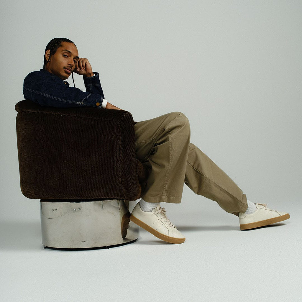 Men's Diamond Cup sneaker in Black leather, ecru pair worn by a man seated in a brown chair