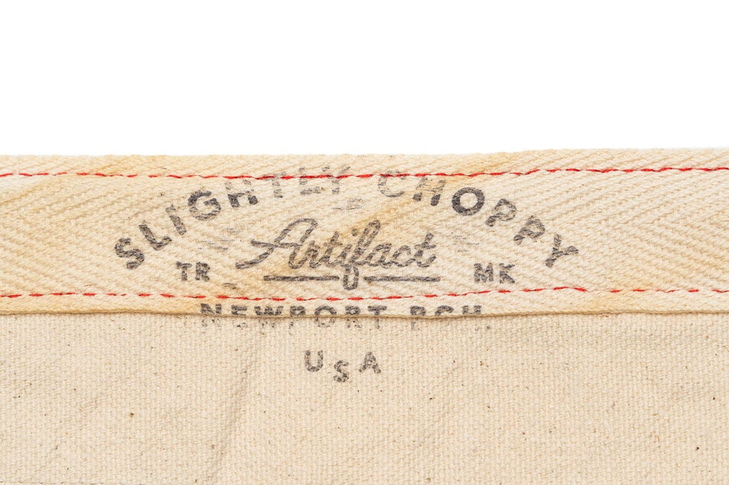 Close up of the Slightly Choppy Artifact label on cream fabric