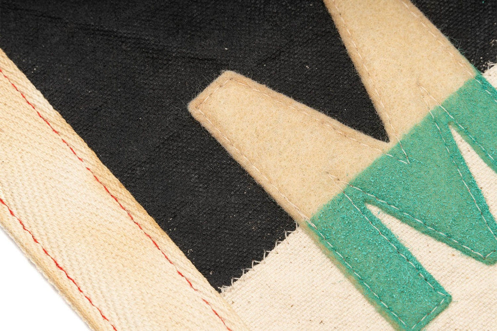 Close up of teal and cream stitched lettering on the Malibu felt pennant