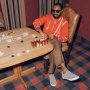 Men's Hawthorne Slip On in Pavement suede, worn with brown pants by a person seated at a game table