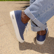 Men's Legend Sneaker in True Navy canvas, close-up worn with cuffed jeans, sole edge visible