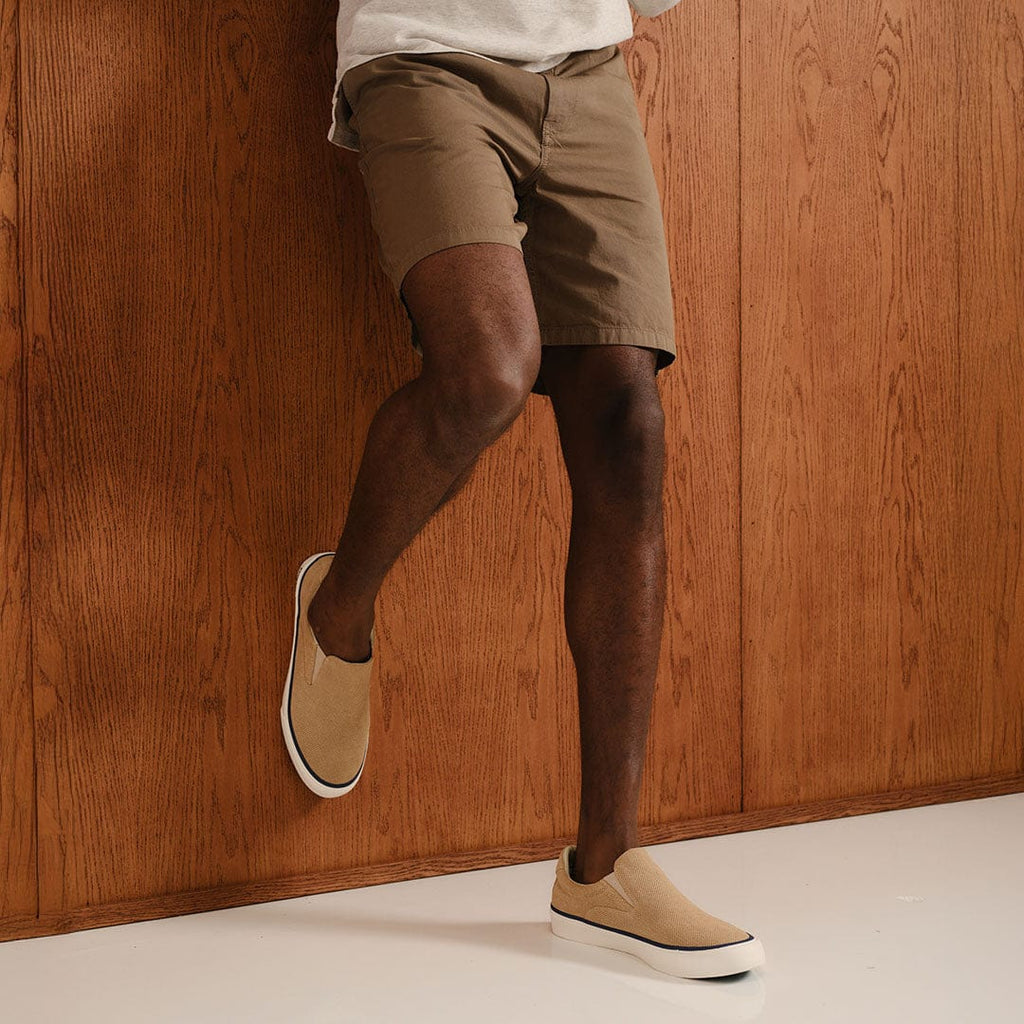 Men's Hawthorne Slip On in Camel suede, worn with khaki shorts, standing on one leg