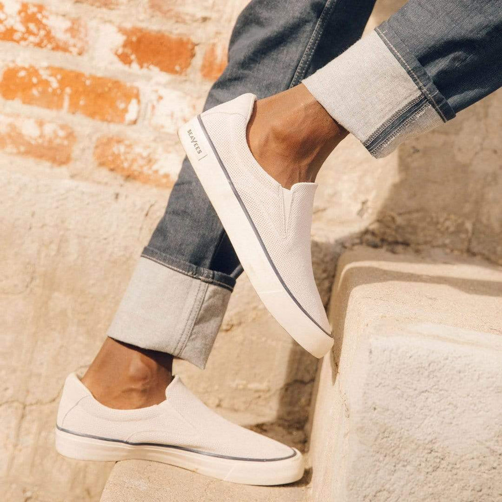 Men's Hawthorne Slip On in Ecru suede, close-up worn with cuffed jeans on stone steps