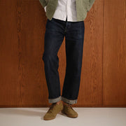 Men's Sun-tans Buck in Dusty Olive suede, worn with cuffed dark jeans against a wood-paneled wall