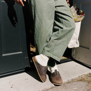 Men's Tiburon Trekker sandal in Bark leather, worn with olive pants and white socks on a concrete step