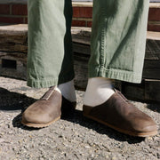Men's Tiburon Trekker sandal in Bark leather, worn with olive pants and white socks on gravel
