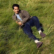 Men's Tiburon Trekker sandal in Espresso suede, worn by a person lying in a grassy field