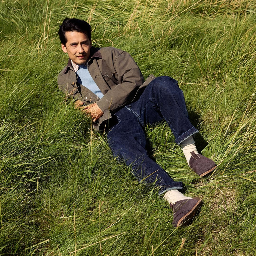 Men's Tiburon Trekker sandal in Espresso suede, worn by a person lying in a grassy field