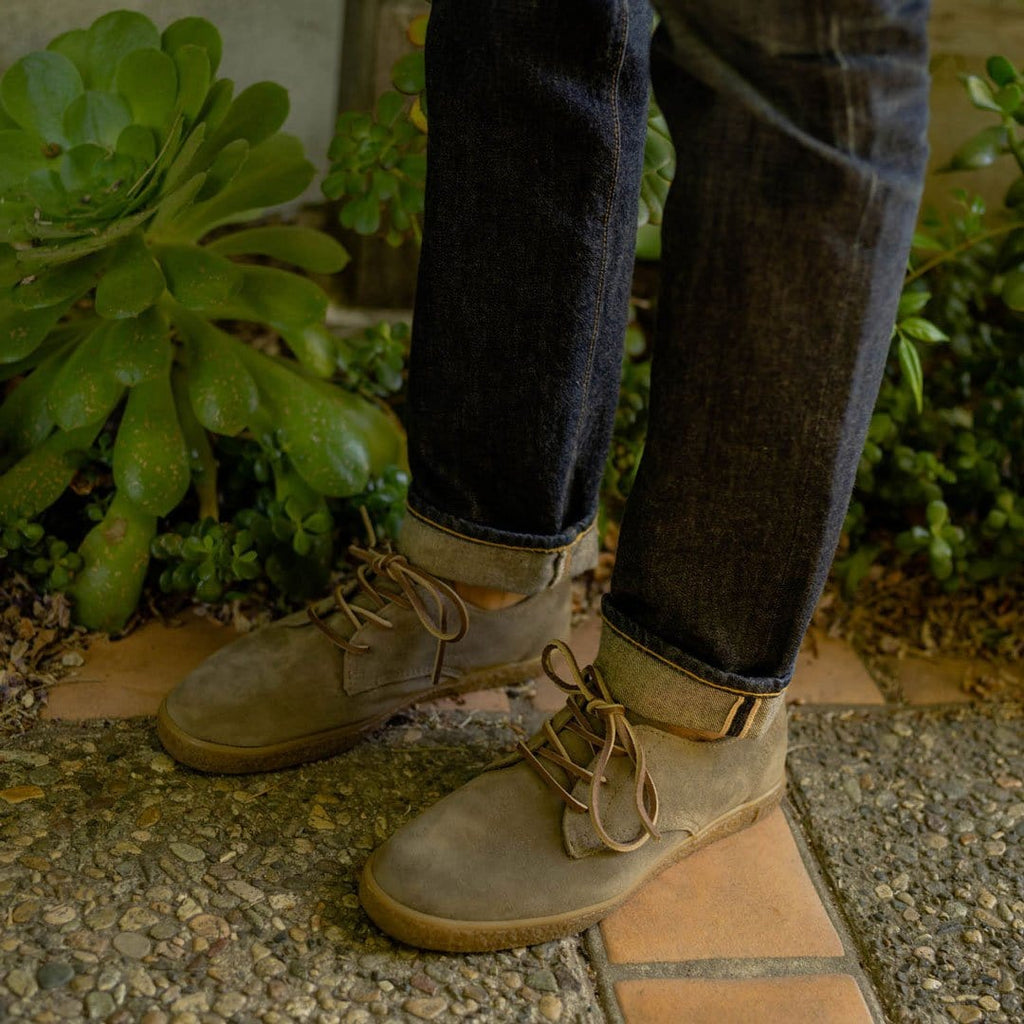Men's Sun-tans Buck in Fossil suede, close-up worn with cuffed jeans on a tile patio