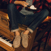 Men's Sun-tans Buck in Fossil suede, worn with cuffed jeans by a person seated at a piano