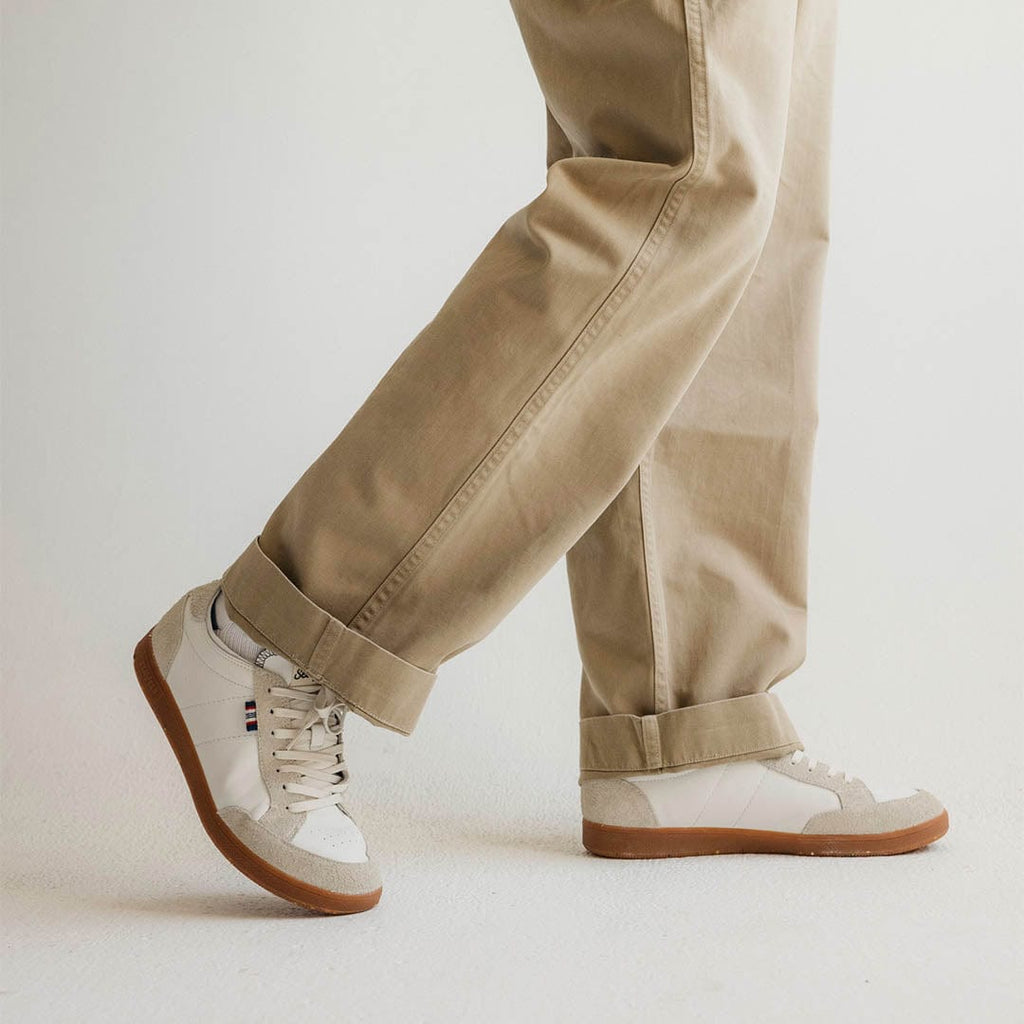 Men's Clipper Sneaker in White leather and suede, worn with khaki pants walking in a studio