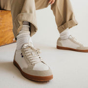 Men's Clipper Sneaker in White leather and suede, worn with khaki pants and white socks, seated