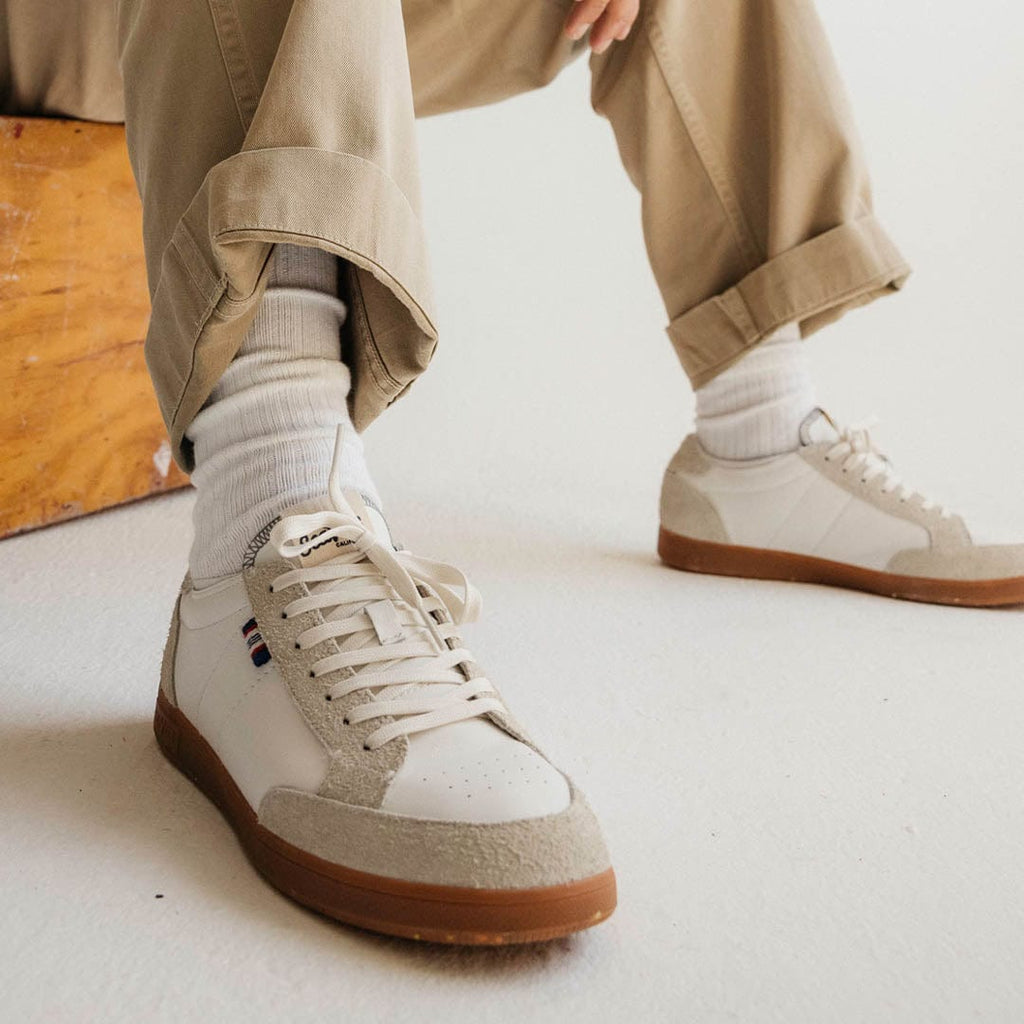 Men's Clipper Sneaker in White leather and suede, worn with khaki pants and white socks, seated