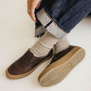 Men's Hawthorne Slip On in Kona leather, close-up worn with cuffed jeans and cream socks, gum sole visible