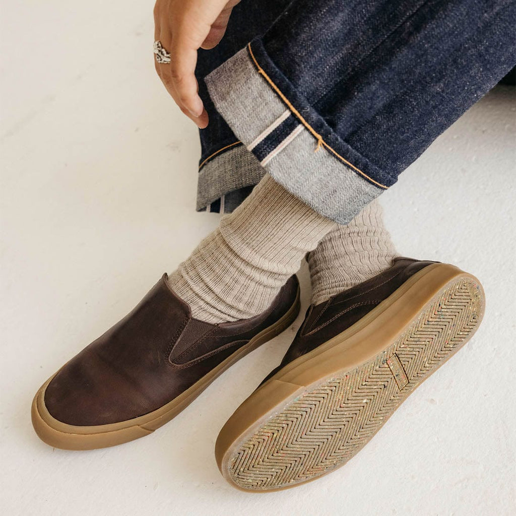 Men's Hawthorne Slip On in Kona leather, close-up worn with cuffed jeans and cream socks, gum sole visible