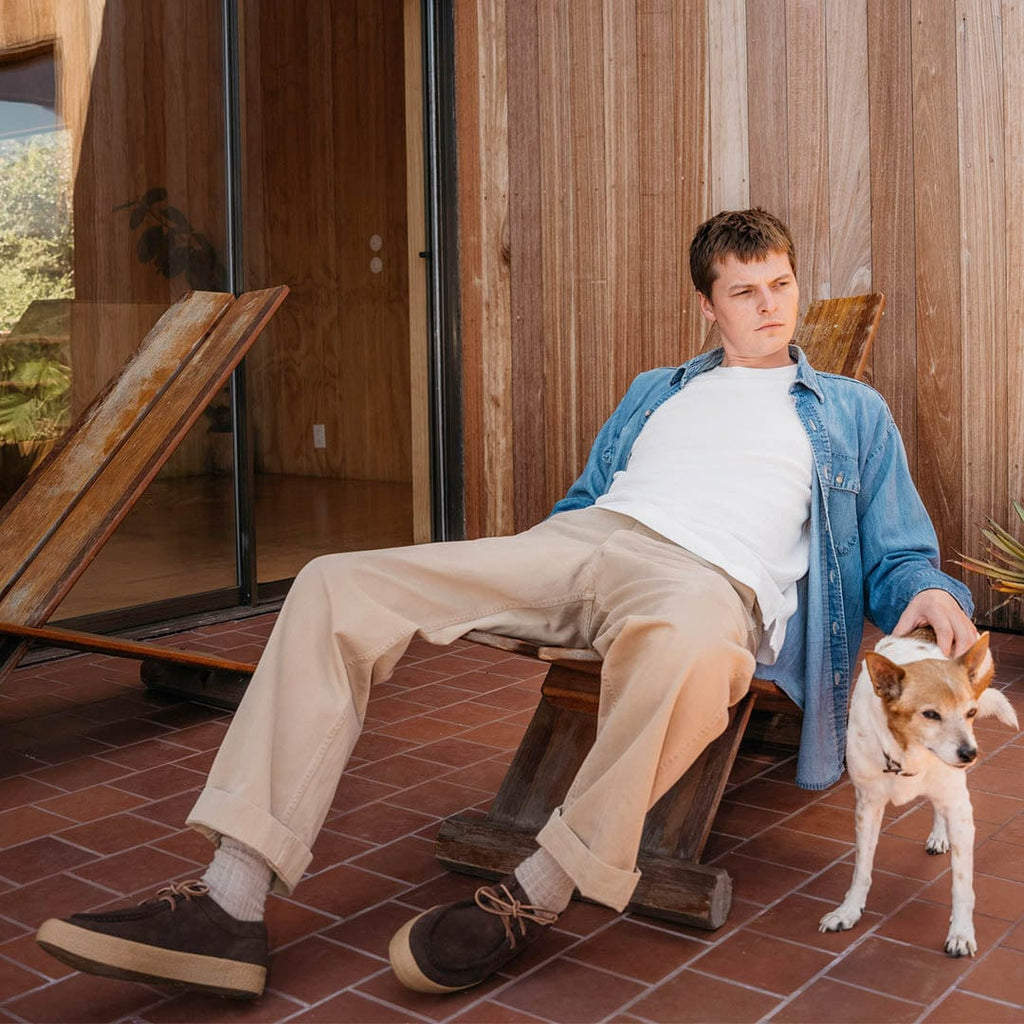 Men's Hayward Loafer in Chocolate suede, worn by a person seated outdoors with a dog