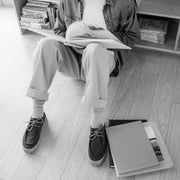 Men's Hayward Loafer in Chocolate suede, black and white shot worn by a person seated reading