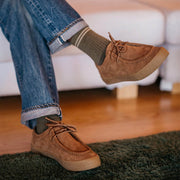 Men's Hayward Loafer in Tobacco suede, worn with rolled jeans, seated on a white sofa