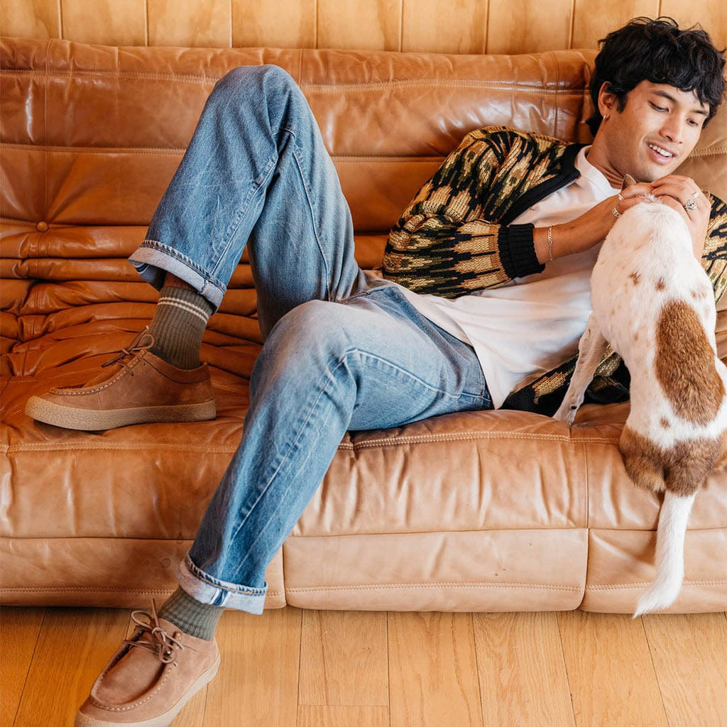 Men's Hayward Loafer in Tobacco suede, worn by a person lounging on a leather sofa with a dog