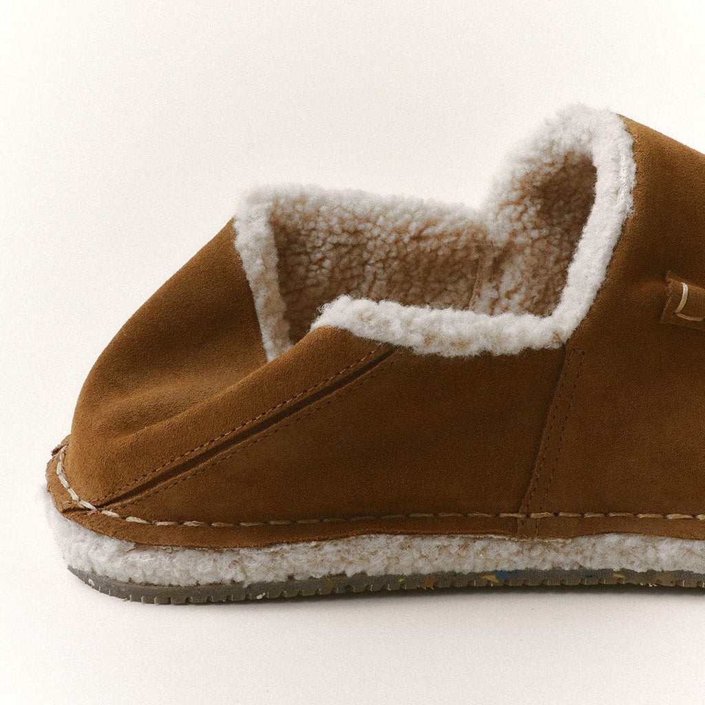 Men's Lodge Slipper in Nutmeg suede, side view showing the shearling lining and sole