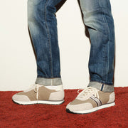 Men's Royal Runner sneaker in Latte nylon and suede, worn with cuffed jeans on a red carpet