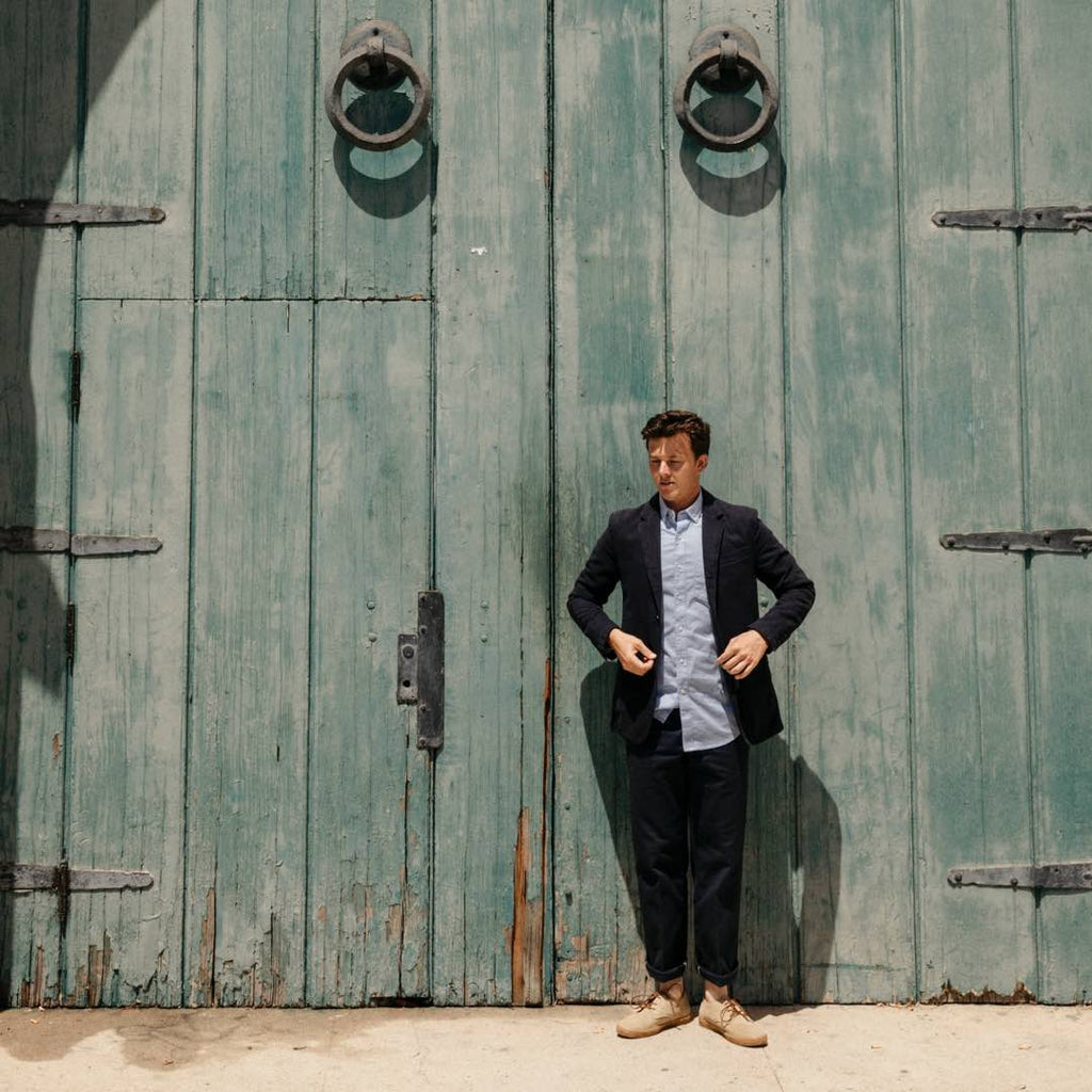 Men's Sun-tans Buck in Sandstone suede, worn with dark pants by a person standing against green wooden doors