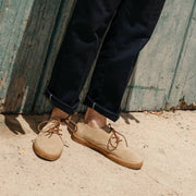 Men's Sun-tans Buck in Sandstone suede, worn with dark cuffed pants against a green wood wall