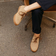 Men's Sun-tans Buck in Sandstone suede, worn by a person seated in an office chair with feet crossed