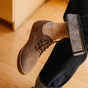 Men's Sun-tans Buck in Fossil suede, close-up worn with cuffed jeans, one foot crossed over the knee