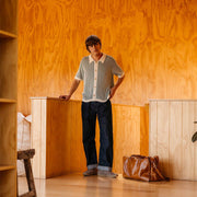 Men's Sun-tans Buck in Fossil suede, worn with dark jeans, full-length view in a wood-paneled room