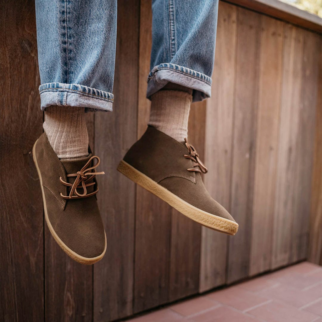 Men's Sun-tans Chukka in Desert Palm suede, close-up of both boots mid-air, worn with cuffed jeans