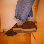 Men's Sun-tans Chukka in Desert Palm suede, close-up worn with cuffed jeans on a wood floor