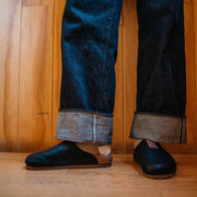 Men's Tiburon Trekker sandal in Black leather, worn with rolled jeans, standing front view
