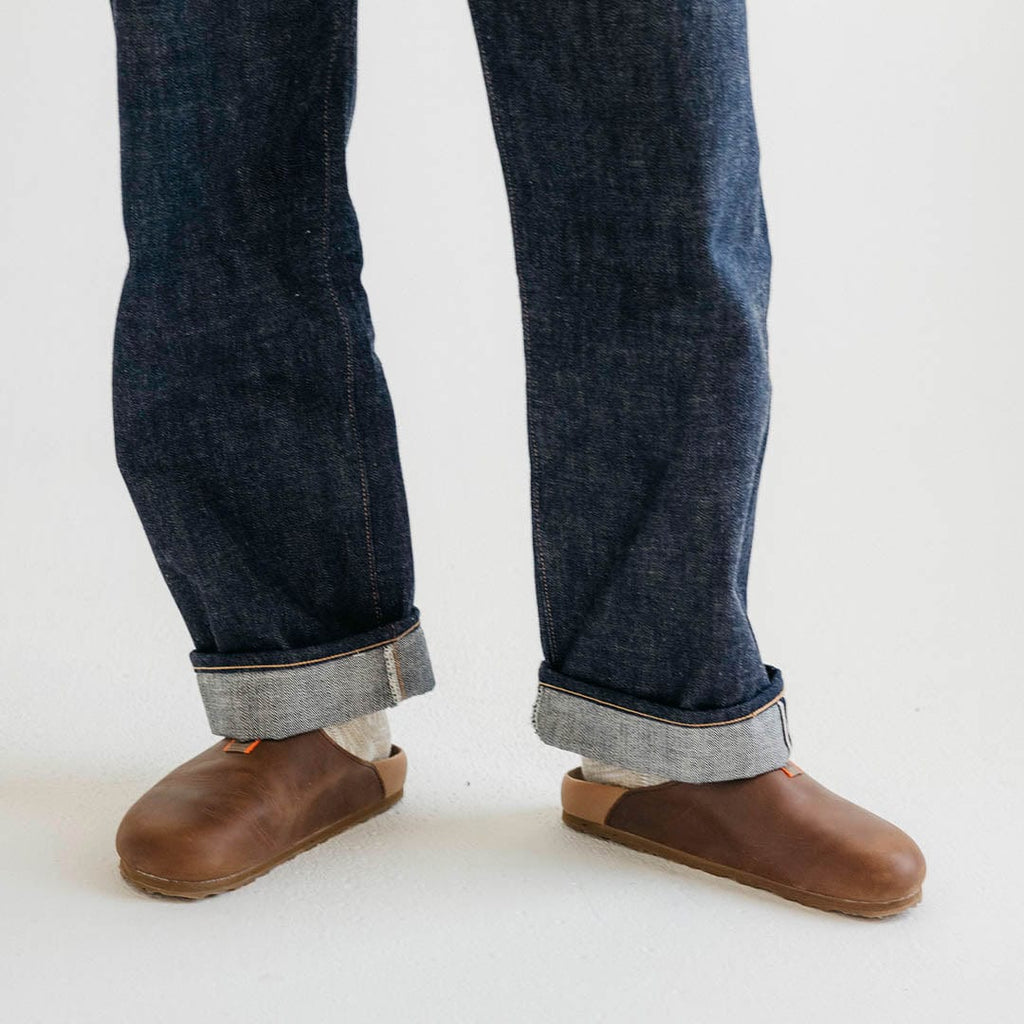 Men's Tiburon Trekker sandal in Elmwood leather, worn with dark rolled jeans, standing front view