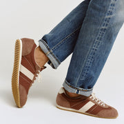 Men's Wilcox Low Profile Trainer sneaker in Cinnamon nylon and suede, worn with cuffed jeans, one foot raised showing the gum