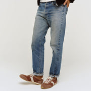Men's Wilcox Low Profile Trainer sneaker in Cinnamon nylon and suede, worn with faded jeans on a light background