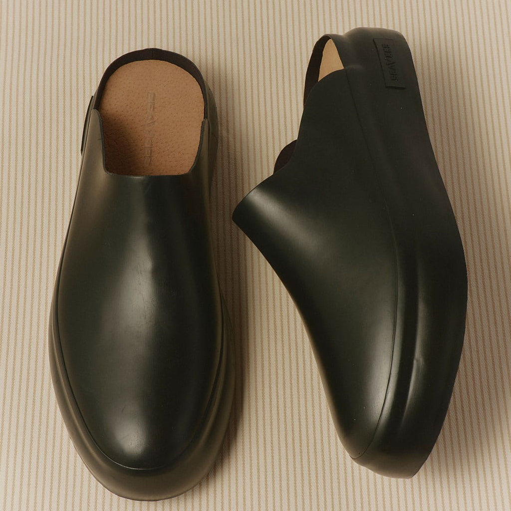Men's Williams Mule in Black rubber, pair on a tan background, one on its side