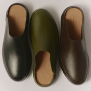 Men's Williams Mule in Black rubber, three pairs side by side in different colors on a tan background