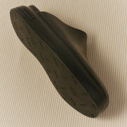 Men's Williams Mule in Black rubber, outsole view on a tan background