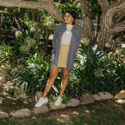 Women's Monterey Sneaker in Bleach canvas, worn with a khaki skirt, full-length view in a garden