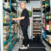 Men's Calistoga Clog in Concrete rubber, worn by a person standing in a commercial kitchen pantry