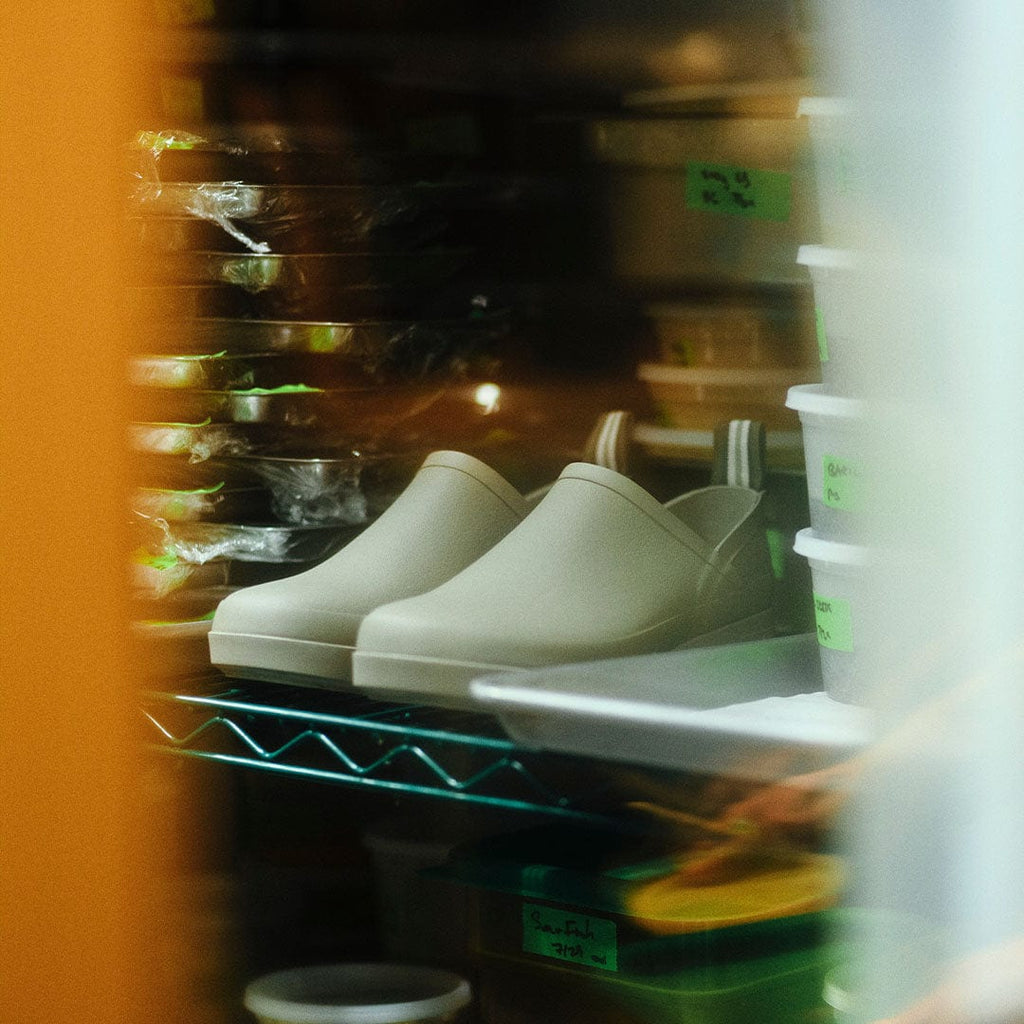 Women's Calistoga Clog in Concrete rubber, pair on a metal shelf in a kitchen, blurred background