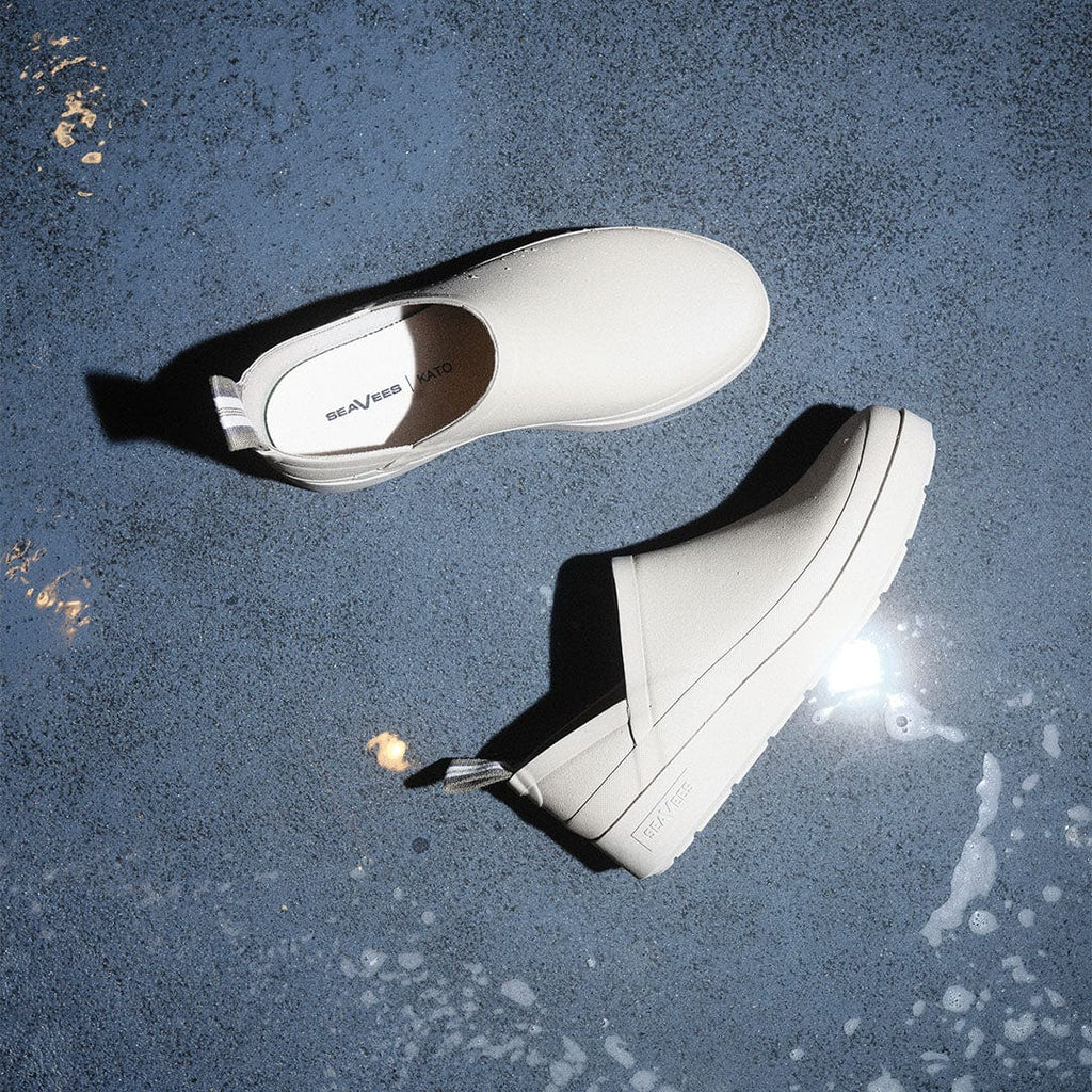 Men's Calistoga Clog in Concrete rubber, pair floating over a wet blue surface, top view