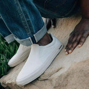 Men's Hawthorne Slip On in Bleach fabric, worn with rolled jeans, one foot on a sandstone rock