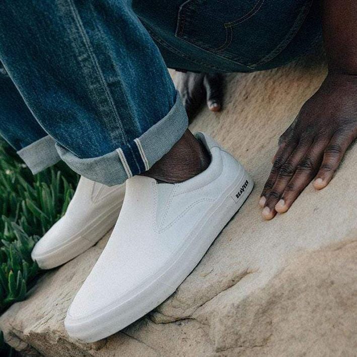 Men's Hawthorne Slip On in Bleach fabric, worn with rolled jeans, one foot on a sandstone rock